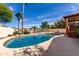 Backyard pool with lush landscaping and a stone-pillared pergola at 12853 E Yucca St, Scottsdale, AZ 85259