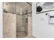 Close up of shower with stone-look tiling, glass shower door, and overhead shower fixture at 12853 E Yucca St, Scottsdale, AZ 85259