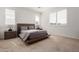 Comfortable bedroom with neutral tones, carpet flooring, and stylish wooden bed frame at 13228 W Buckskin Trl, Peoria, AZ 85383