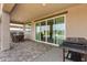 Covered patio with stylish pavers, outdoor dining set, sliding glass doors, and a built-in grill at 13228 W Buckskin Trl, Peoria, AZ 85383