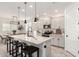 Well-lit kitchen showcasing white cabinetry, a central island, and stainless steel appliances with modern pendants at 13228 W Buckskin Trl, Peoria, AZ 85383