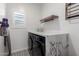 Bright laundry room with black-and-white patterned floors, modern washer and dryer, and a marble countertop at 13228 W Buckskin Trl, Peoria, AZ 85383
