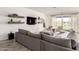 Spacious living room featuring a large gray sectional sofa and sliding glass doors to the backyard at 13228 W Buckskin Trl, Peoria, AZ 85383