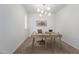 Minimalist office space featuring a light wood desk, chair, and modern light fixture at 13228 W Buckskin Trl, Peoria, AZ 85383