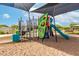 Community playground featuring modern climbing structures, a slide, and a sand-covered play area at 13228 W Buckskin Trl, Peoria, AZ 85383
