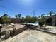 Partially landscaped backyard with pool, fire pit, mature trees, and patio at 1529 W Eva St, Phoenix, AZ 85021