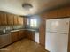 Corner kitchen with wood cabinetry, stainless steel appliances, and tiled flooring at 1529 W Eva St, Phoenix, AZ 85021