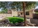 Charming backyard featuring a well-manicured lawn, mature trees, and a cozy covered patio at 15420 W Canterbury Dr, Surprise, AZ 85379