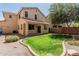 A spacious backyard with lush green grass, a decorative rock border, and a covered patio at 15420 W Canterbury Dr, Surprise, AZ 85379