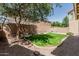 A well-maintained backyard boasts green grass and a small rock water feature at 15420 W Canterbury Dr, Surprise, AZ 85379