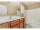 Bathroom with a wooden vanity and white countertop and a tiled shower/tub combo at 15420 W Canterbury Dr, Surprise, AZ 85379