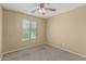 A bedroom featuring neutral walls, a ceiling fan with lighting, and a window with blinds at 15420 W Canterbury Dr, Surprise, AZ 85379