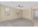 Large bedroom with neutral carpet, ceiling fan, and ample natural light at 15420 W Canterbury Dr, Surprise, AZ 85379
