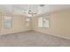 Large, bright bedroom featuring neutral carpet and a ceiling fan at 15420 W Canterbury Dr, Surprise, AZ 85379