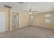 Spacious main bedroom featuring neutral walls, carpet flooring, a ceiling fan, and ensuite bath at 15420 W Canterbury Dr, Surprise, AZ 85379
