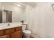Bright bathroom with a wood vanity, toilet and shower with bright natural light at 1577 E Earl Dr, Casa Grande, AZ 85122