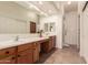 Well-lit bathroom with dual sinks, wooden cabinetry, and tile flooring at 1577 E Earl Dr, Casa Grande, AZ 85122