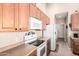 Well-maintained kitchen featuring oak cabinets, white appliances, and tile flooring at 1577 E Earl Dr, Casa Grande, AZ 85122