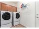 Well-equipped laundry room with cabinets, shelving, and modern side by side washer and dryer at 1577 E Earl Dr, Casa Grande, AZ 85122