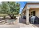 Relaxing back patio with lush trees and view of well-maintained backyard landscaping at 15976 W La Paloma Dr, Surprise, AZ 85374