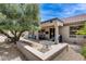 Charming back patio featuring a covered area with outdoor seating and a lush green tree at 15976 W La Paloma Dr, Surprise, AZ 85374