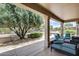 Covered back patio with comfortable seating and a view of the landscaped backyard at 15976 W La Paloma Dr, Surprise, AZ 85374