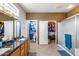 Well lit bathroom featuring double sinks, an enclosed shower, toilet room, and walk-in closet at 15976 W La Paloma Dr, Surprise, AZ 85374