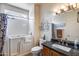Well-lit bathroom with a walk-in tub, modern fixtures, and a granite vanity at 15976 W La Paloma Dr, Surprise, AZ 85374
