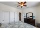 Bedroom with a dark wood dresser, large mirror and a ceiling fan at 15976 W La Paloma Dr, Surprise, AZ 85374
