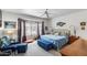 Sunlit bedroom featuring a bay window, ceiling fan and a relaxing blue color scheme at 15976 W La Paloma Dr, Surprise, AZ 85374