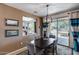 Dining room with a dark wood table, seating for four, and sliding glass doors leading to the outside patio at 15976 W La Paloma Dr, Surprise, AZ 85374