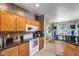 Well-equipped kitchen with granite counters, wood cabinets, and views into other living spaces at 15976 W La Paloma Dr, Surprise, AZ 85374