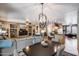 Open concept living room with dining area, modern lighting, neutral furniture, and built-in shelving at 15976 W La Paloma Dr, Surprise, AZ 85374