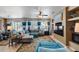 Bright living room with a large sectional, backyard views, and built-in shelving with decor at 15976 W La Paloma Dr, Surprise, AZ 85374
