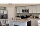 Modern kitchen features white cabinets, granite countertops, and stainless steel appliances at 16046 W Hearn Rd, Surprise, AZ 85379