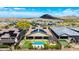 Stunning aerial view of the backyard pool, putting green, solar panels, and mountain views at 16389 W Fawn Dr, Goodyear, AZ 85338