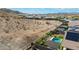 Aerial view showcases a backyard featuring a pool, lounge seating, landscaping, and desert views at 16389 W Fawn Dr, Goodyear, AZ 85338