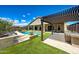 Beautiful backyard with pool, pergola-covered outdoor kitchen, artificial turf, and patio with outdoor dining at 16389 W Fawn Dr, Goodyear, AZ 85338