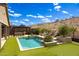 Expansive backyard features pool, outdoor kitchen, lush landscaping and a putting green with desert views at 16389 W Fawn Dr, Goodyear, AZ 85338