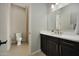 Well-lit bathroom featuring vanity with dark cabinetry and a toilet in separate area at 16389 W Fawn Dr, Goodyear, AZ 85338