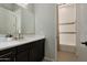 Stylish bathroom featuring a black vanity with white countertop and a tub with white tile surround at 16389 W Fawn Dr, Goodyear, AZ 85338