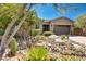 Single-story home with desert landscaping featuring river rock, a paver driveway, and lush succulents at 16389 W Fawn Dr, Goodyear, AZ 85338
