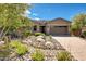 Attractive single-story home with desert landscaping, brick accents, a tile roof, and a paver driveway at 16389 W Fawn Dr, Goodyear, AZ 85338
