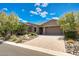 Attractive single-story home with desert landscaping, brick accents, a tile roof, and a paver driveway at 16389 W Fawn Dr, Goodyear, AZ 85338