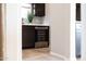 Modern kitchen featuring wine fridge, dark cabinets, light countertops, adjacent to hallway at 16389 W Fawn Dr, Goodyear, AZ 85338