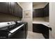 Well-equipped laundry room with washer, dryer, stylish dark wood cabinetry and countertop at 16389 W Fawn Dr, Goodyear, AZ 85338
