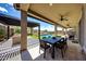 Covered patio featuring an outdoor dining area with a view of the pool and backyard at 16389 W Fawn Dr, Goodyear, AZ 85338