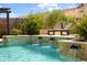 Inviting in-ground pool with stone water features surrounded by desert landscaping and hardscape at 16389 W Fawn Dr, Goodyear, AZ 85338