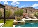 Luxurious pool with beautiful stone features, desert landscaping and mountain views in a private backyard at 16389 W Fawn Dr, Goodyear, AZ 85338
