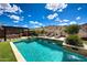 Backyard pool area featuring travertine decking, desert views, outdoor kitchen and artificial turf at 16389 W Fawn Dr, Goodyear, AZ 85338